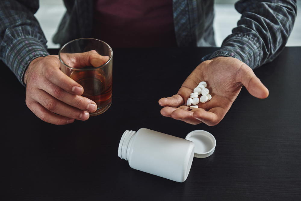 You largely constructed your depression. It wasn't given to you. Therefore, you can deconstruct it. Close up of man sitting at table with alcohol and drugs. Alcoholism concept